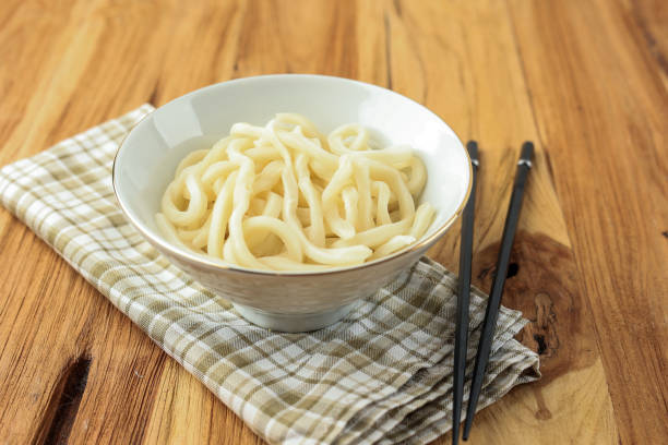 Japanese Udon Noodles on White Bowl Above Wooden Table