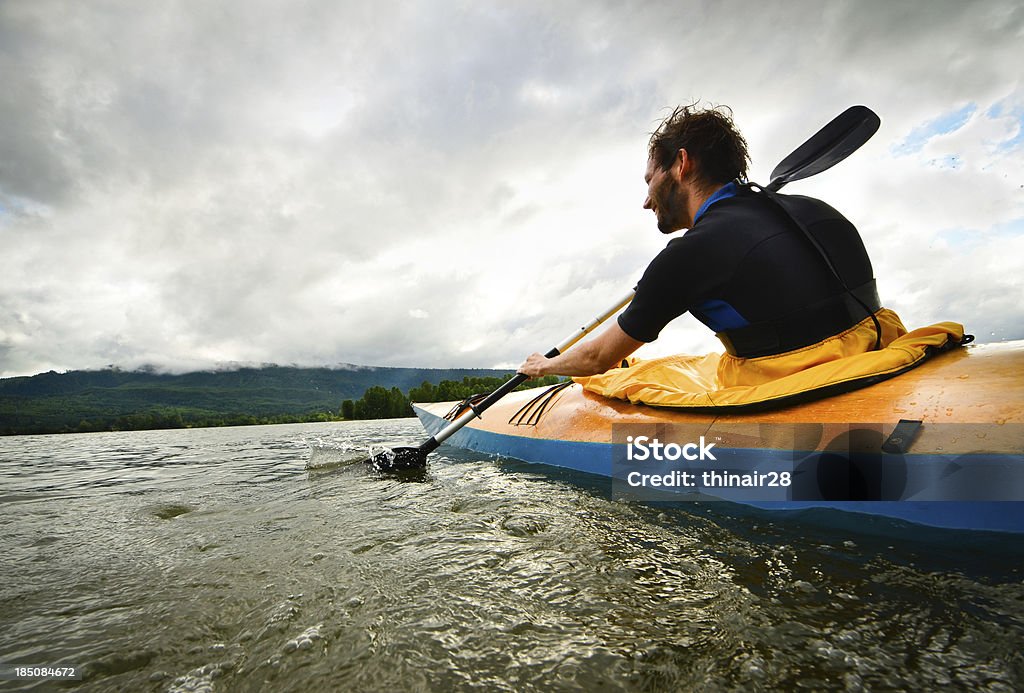 Man paddling in wooden kayak "A man kayaking in a wooden kayak. Columbia River, Washington State." Activity Stock Photo