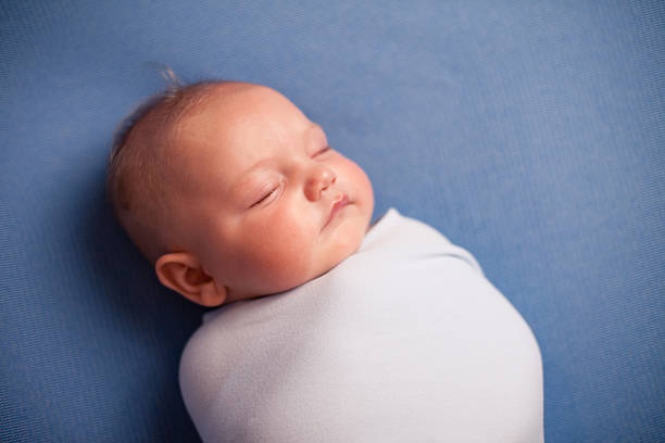 istock Color Image of Swaddled Baby Sleeping Peacefully, on Blue Background 185084837