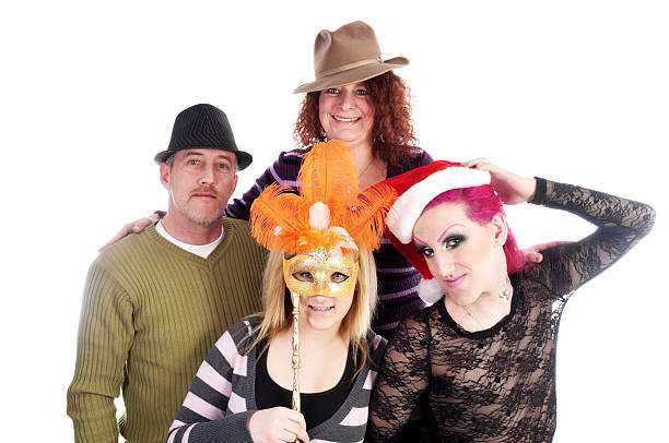 Four person family playing with hats. Horizontal studio shot on white of happy family with transgender (MTF) member. Christmas crossdressing stock pictures, royalty-free photos & images