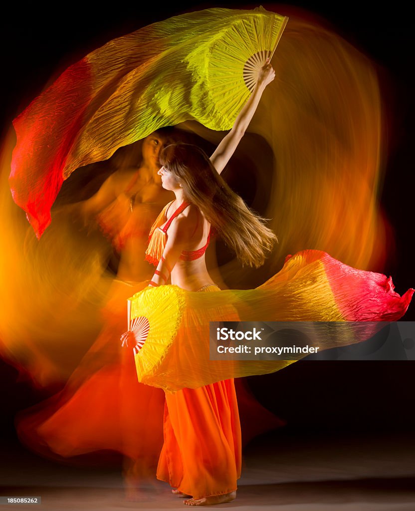 Belly dancer with colorful Fan Veils Belly dancer in motion on black background  Belly Dancing Stock Photo