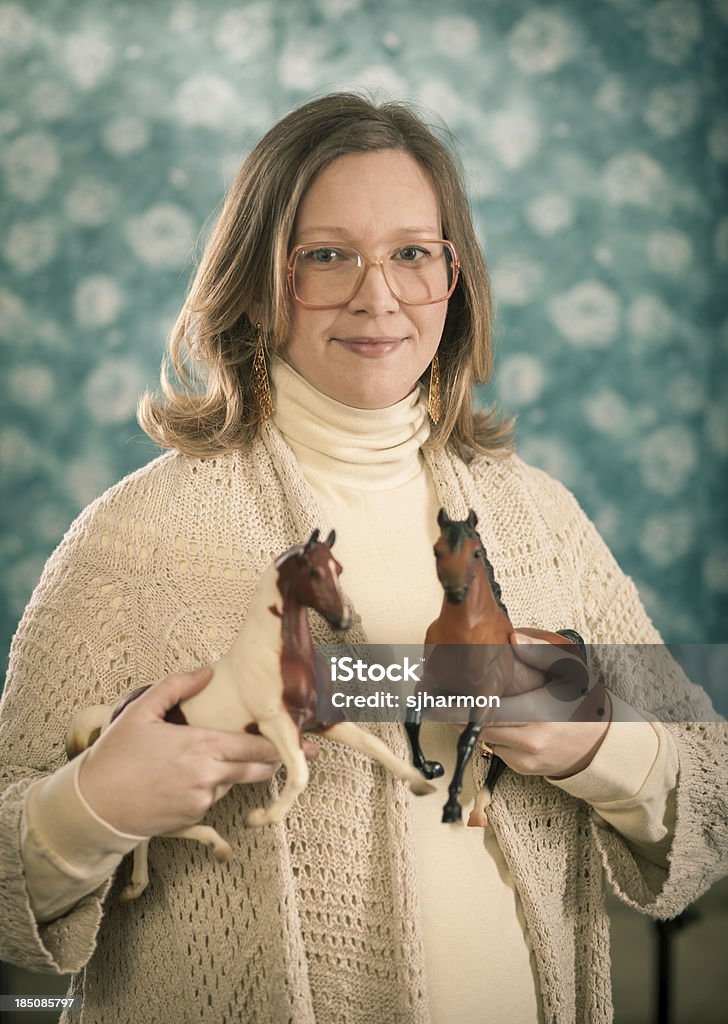 Retrato de mujer rubia sosteniendo un juguete de caballos - Foto de stock de 30-34 años libre de derechos