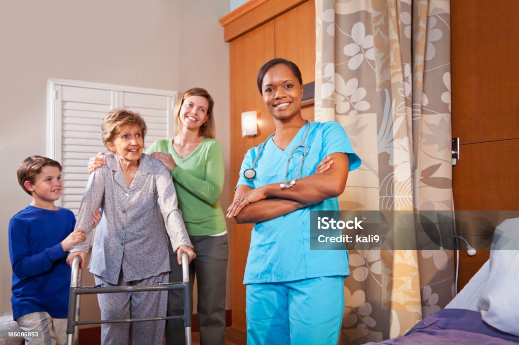 Trabajador de asistencia sanitaria en el hospital con paciente senior y famil - Foto de stock de 30-39 años libre de derechos