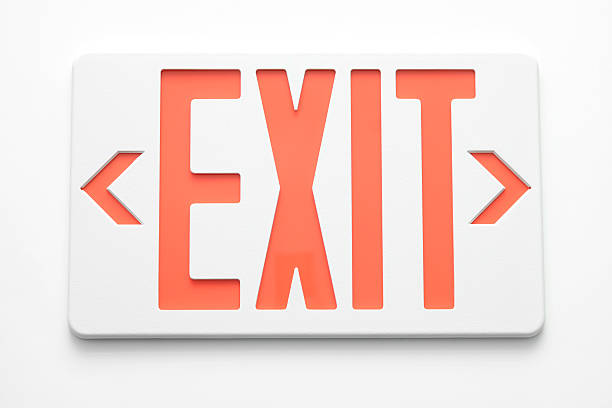 Emergency exit signs on white wall Close up of an Emergency Exit Sign against a white background.   exit sign stock pictures, royalty-free photos & images