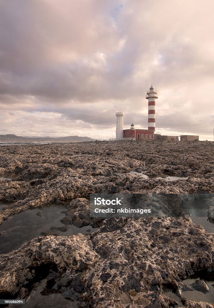 Old lighthouse with rocky coast Vertical image of an old lighthouse on Fuerteventura. Related: Atlantic Islands Stock Photo