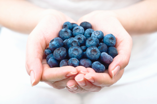 Beautiful blueberry on a wooden background. Вlueberry in the palm. Quality image for your project