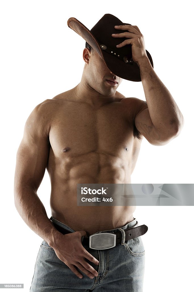 Regolando il suo cappello da Cowboy - Foto stock royalty-free di Cowboy