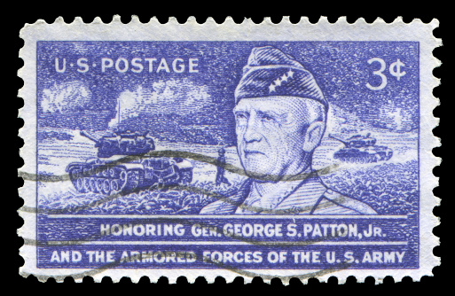 US postage stamp: George Patton with the battlefield background.