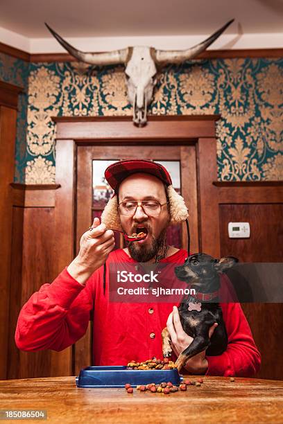 Backwoods Man Eats His Dogs Kibble At Kitchen Table Stock Photo - Download Image Now