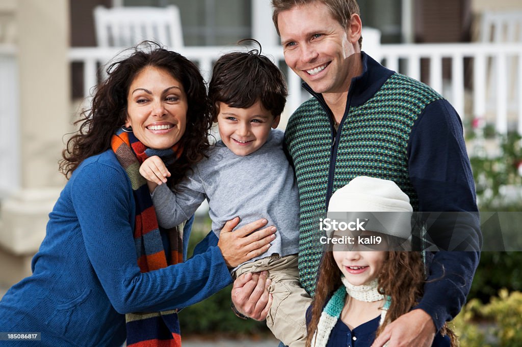 Family with two children standing in front of house Family with two children (3 and 9 years) standing in front of home.  (Girl not in focus). Family Stock Photo
