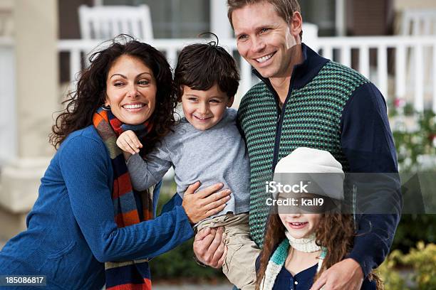 Family With Two Children Standing In Front Of House Stock Photo - Download Image Now