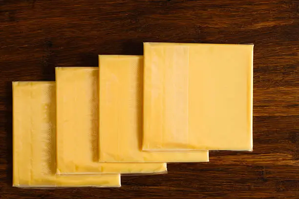 Wrapped cheese slices on a cutting board