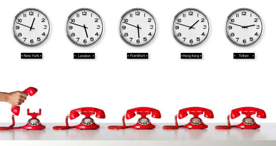 This is a photo of 5 red telephones sitting below five clocks with different time zones around the world. The background is a pure white allowing for the end user to add more copy space between the clocks and the phones if needed.There are similar images in the telephone lightbox below.