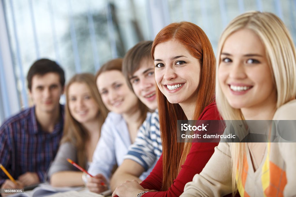 Gruppo di felici studenti del college in aula - Foto stock royalty-free di Abbigliamento casual