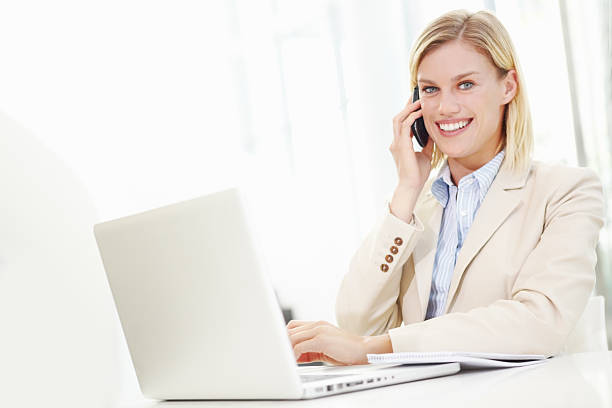 istock Businesswoman using cellphone and laptop 185088636