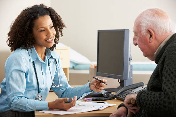 Young female Doctor with senior male patient Smiling young female Doctor with senior male patient. general practitioner stock pictures, royalty-free photos & images