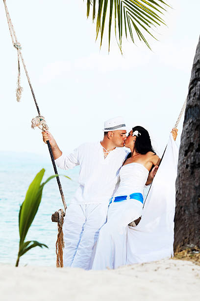 istock Beautiful couple enjoying while swinging on the beach 185089089