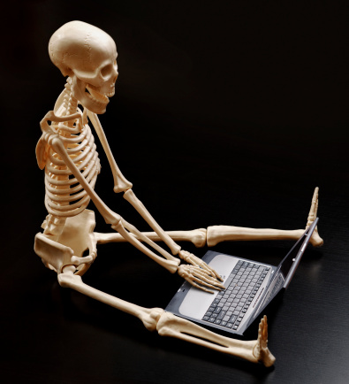 isolated on black skeleton with hands on a laptop