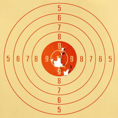 Paper pistol target, with hits in the high scoring centre of the target.