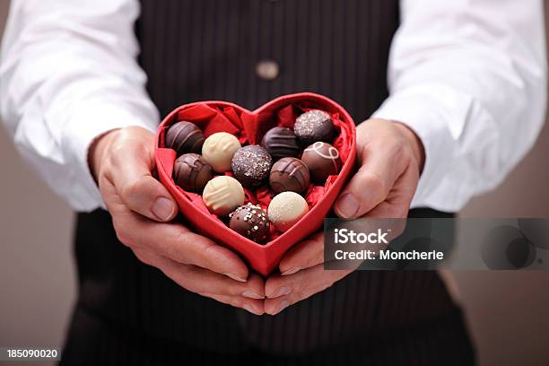Hombre Dando Un Corazón En Forma De Chocolate Pecán Garrapiñadas Foto de stock y más banco de imágenes de Chocolate