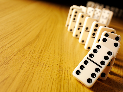 Dominoes with the domino effect on a wooden background with copy spaceClick on the link below to see more of my business and leisure game images.