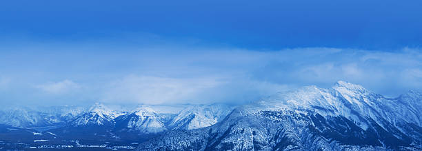Panorama of Banff National Park Mountain Range Panoramic winter scene at Banff National Park Mountain Range as seen from the Gondola Mountaintop Experience site (Sulphur Mountain)processed in blue tones only. ca04 stock pictures, royalty-free photos & images