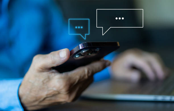 istock Human hand using smartphone typing Live chat chatting and social network concepts, chatting conversation working at home in chat box icons pop up. Social media marketing technology concept 1850912408