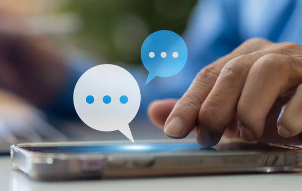 istock Human hand using smartphone typing Live chat chatting and social network concepts, chatting conversation working at home in chat box icons pop up. Social media marketing technology concept 1850912413