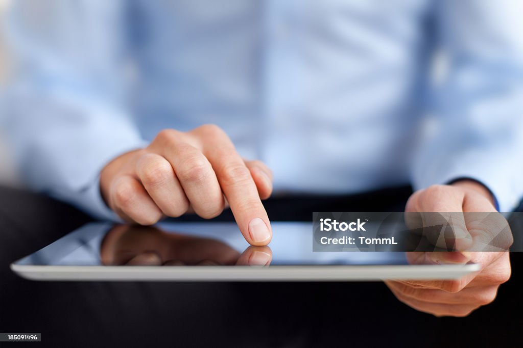 Man working on digital tablet Hands of a casual man holding a digital tablet. Adult Stock Photo