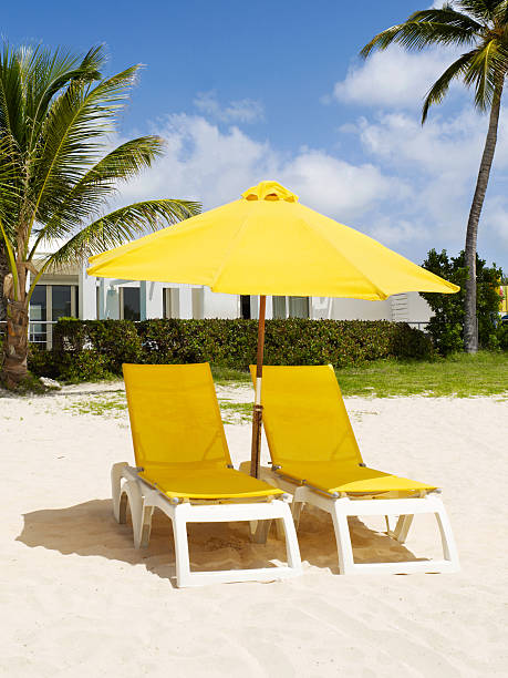 Beach scene with yellow lounge chairs and umbrella