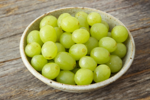 Natural light photo of small bowl of organic green grapes on rustic wood backgroundPlease view more rustic food images here: