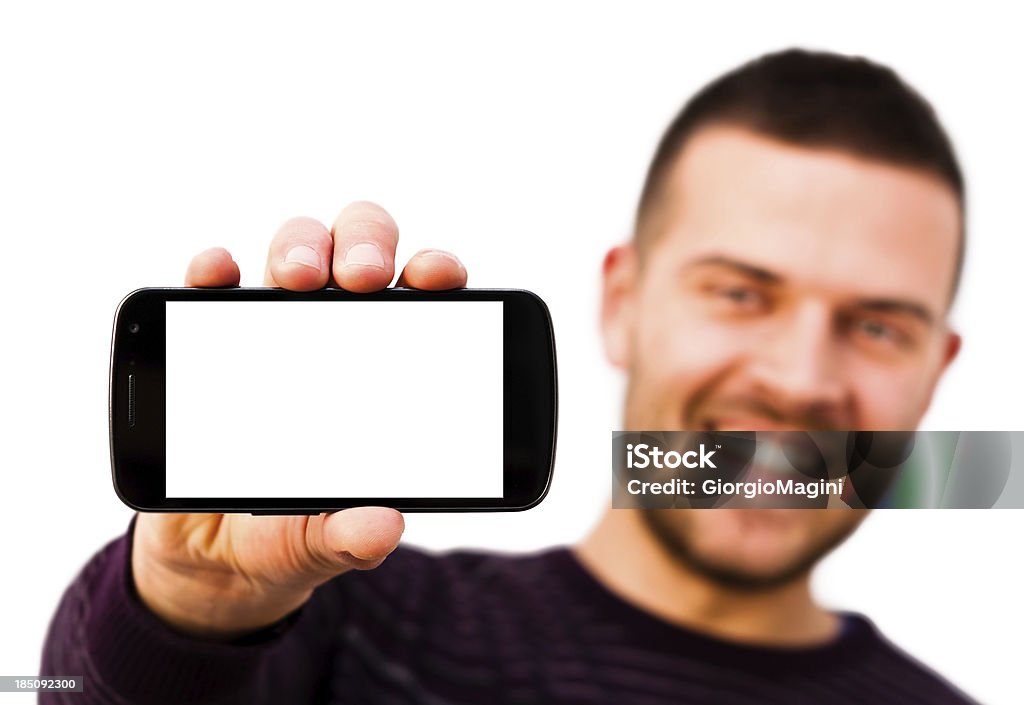 Smiling Man with Blank Screen Smartphone, White Background Smiling young man holding a smartphone with a huge blank screen. Studio shot on white backgound. 25-29 Years Stock Photo