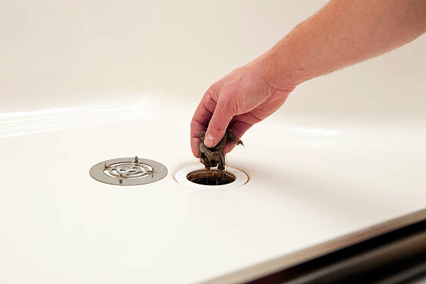 istock Plumber Removing Hair Clog from Shower Drain 185092331