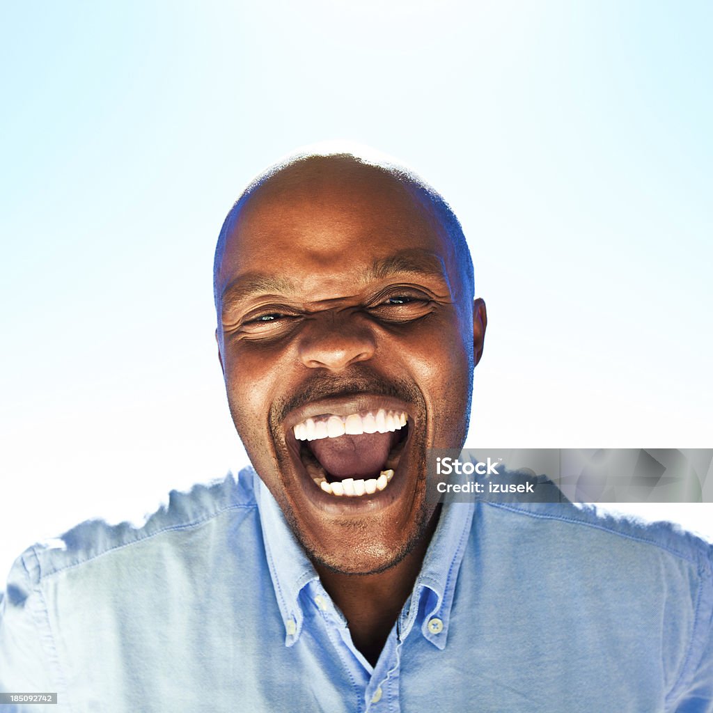 Happiness Happy man laughing at the camera against blue sky. Adult Stock Photo
