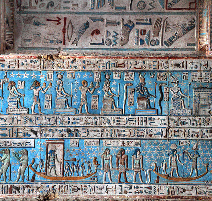 The vibrant astronomical ceiling of the Hypostyle Hall, Temple of Hathor Dendera, Egypt.  The ceiling is a symbolic representation of the heavens, featuring the waxing and waning of the moon as it travels across the heavens in the barque of Re.  Jackals and birds accompany Re’s barque.  This scene is from the east side of the temple and features snakes and various gods including, the falcon god Horus, the ibis headed god Thoth, Hathor and Sekhmet (also Sachmet, Sakmet, Sakhet, Sekmet, Sakhmet, Sekhet, Sachmis), the lion goddess of war and destruction.  Dedicated to Hathor, goddess of love, beauty, music and motherhood, the main temple dates from the Graeco-Roman era although a temple stood on the site during the Old Kingdom.