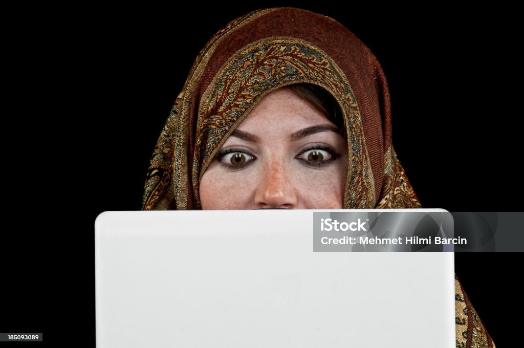 Muslim Woman Using Laptop Islamic woman searching her hobies to laptop against black background Abaya - Clothing Stock Photo