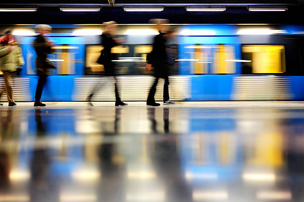 Subway train in profile, and commuters "Motion blurred commuters in silhouette and subway trainStockholm, Sweden.Similar pictures" standing on subway platform stock pictures, royalty-free photos & images
