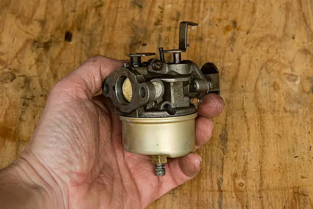 Mechanic holds small gasoline engine carburetor20100221053See more in my Small Engine Repair lightbox: