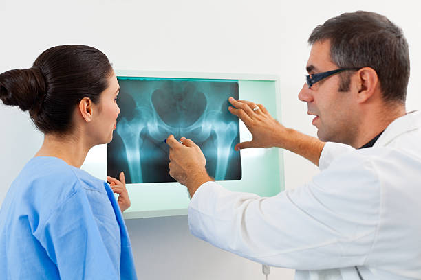 médicos examinar uma radiografia de imagem - x ray image radiologist examining using voice imagens e fotografias de stock