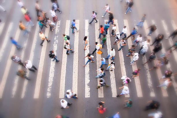 Crosswalk "Large zebra crossing in the city, busy blurred people in the background going into different directions" zebra crossing photos stock pictures, royalty-free photos & images