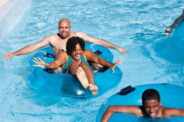 афро-американской семьи, весело в воде парк - water sport family inner tube sport стоковые фото и изображения