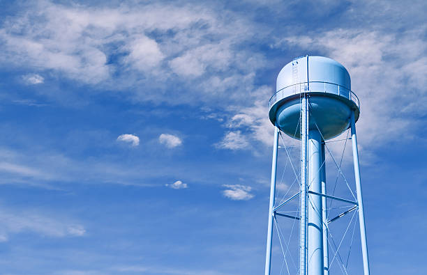 Water tower with wispy clouds in sky behind stock photo