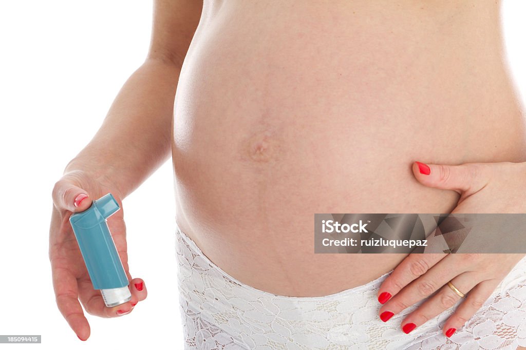 A pregnant woman holding an Asthma inhaler Unrecognizable pregnant woman with asthma inhaler Abdomen Stock Photo