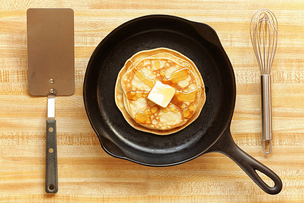 Making Pancakes "Serving of pancakes in which fork, knife, and plate have been replaced with spatula, pan, and whisk." cooking pan overhead stock pictures, royalty-free photos & images