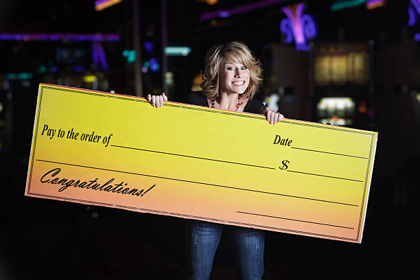 Happy Woman Holding Giant Check In a Casino stock photo