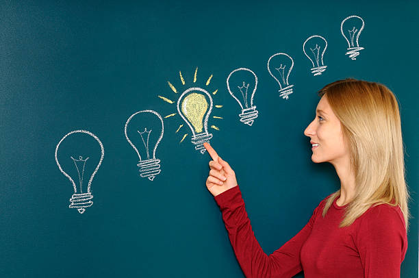 istock Young Woman Pointing a Light Bulb 185094627
