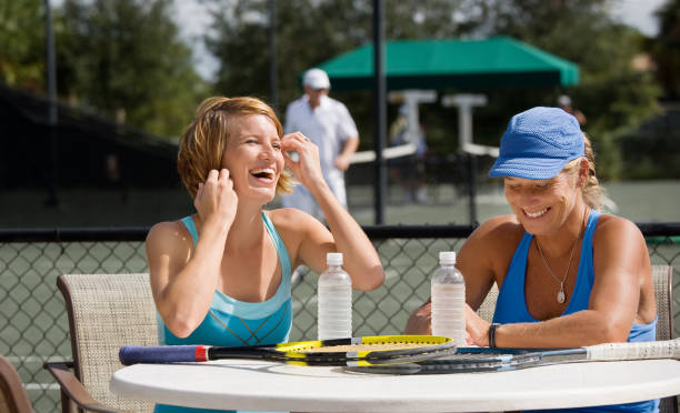 mother daughter tennis players doubles partners mother and daughter taking a break at the tennis club. country club stock pictures, royalty-free photos & images