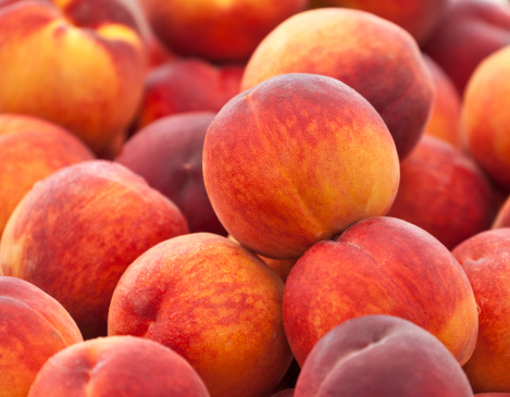 Heap of fresh organic peaches on display at a market.