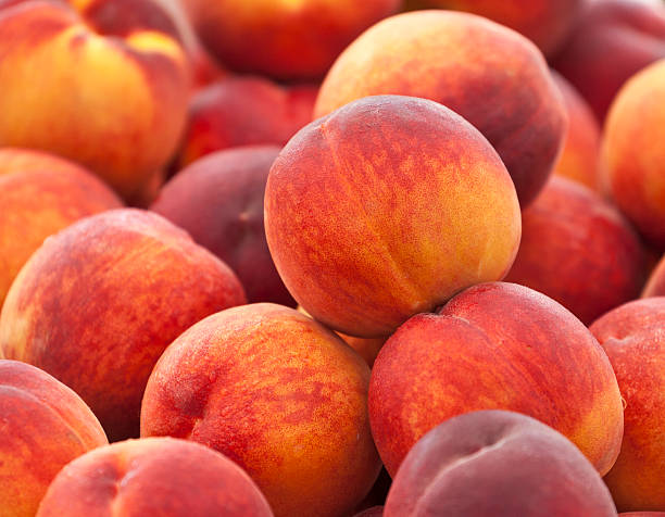 Fresh Peaches Heap of fresh organic peaches on display at a market. peach photos stock pictures, royalty-free photos & images