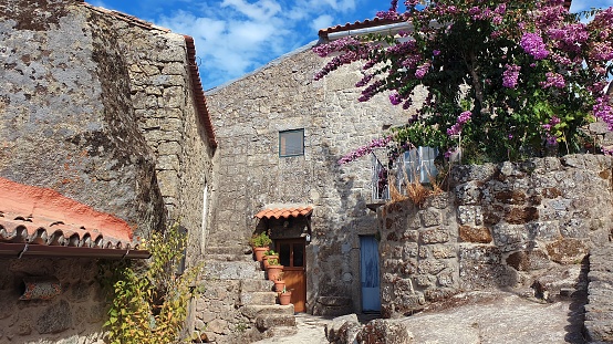 In the picturesque village of Monsanto, Portugal, an old local cottage crafted from granite stone seamlessly blends into its surroundings. A quaint testament to the timeless beauty of rural life.